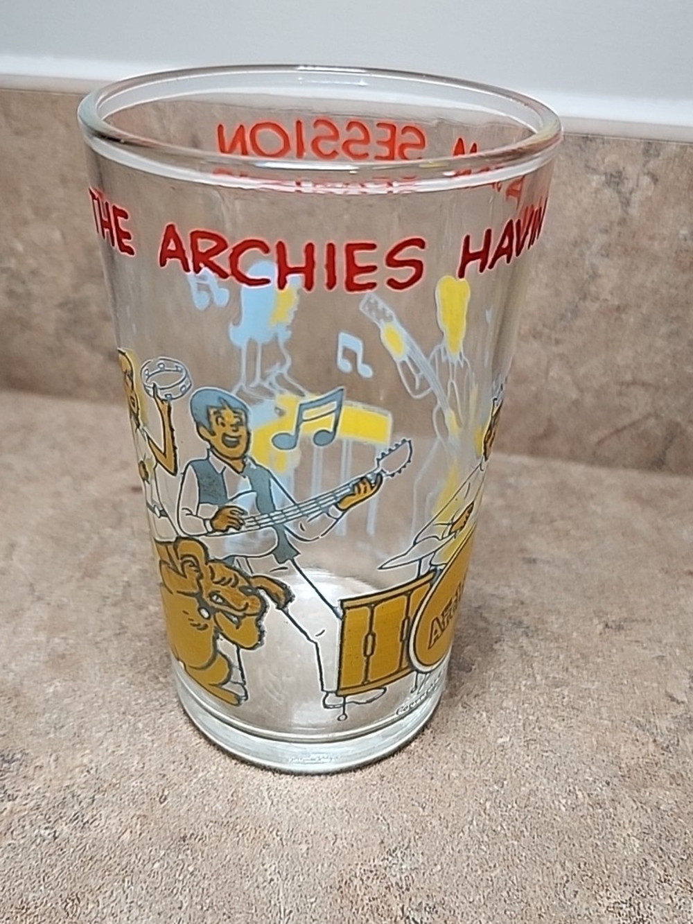 The Archies Clear Glass Tumbler with Red and Yellow Band Graphics